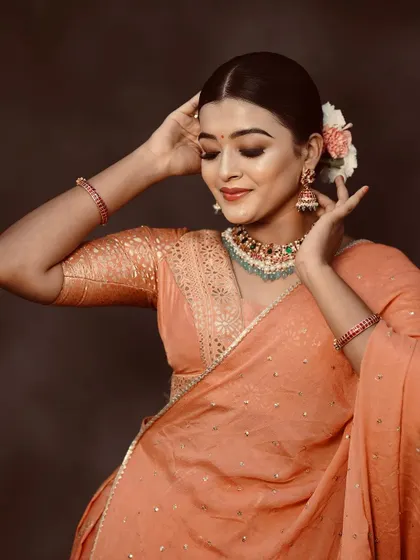 This image captures the grace and elegance of the model in our peach lehenga, showing how beautifully it drapes.
