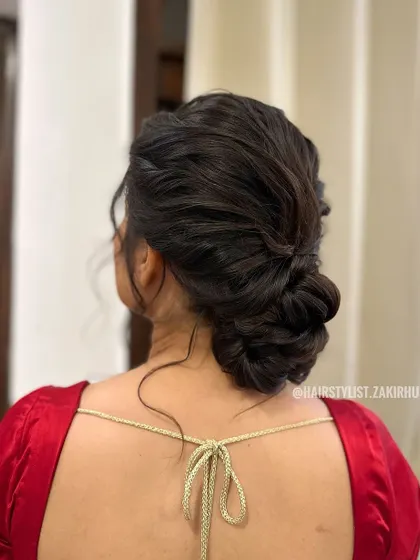 A textured and twisted low bun without any accessories. This showcases the intricate hairstyling itself, perfect for a client who prefers a minimalist look.