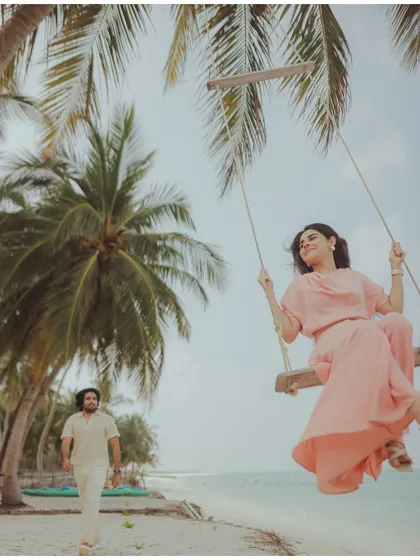 Carefree moments on a beach swing in Lakshadweep. This image captures a sense of playful romance against the backdrop of palm trees and the ocean.
