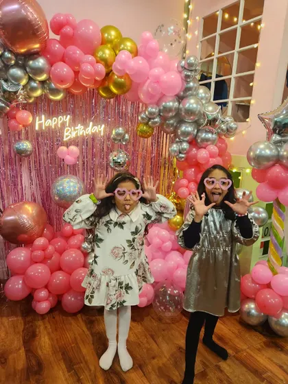 Just some monkey business! Two girls making funny faces for the camera in front of the popstar backdrop.