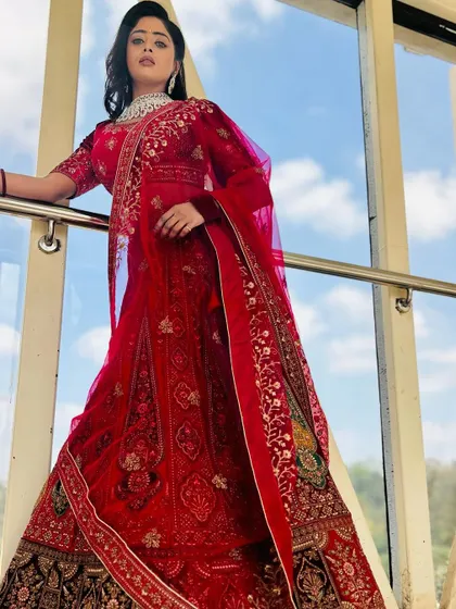 A full-length shot of the red reception lehenga, perfectly complemented by the sparkling CZ choker set.
