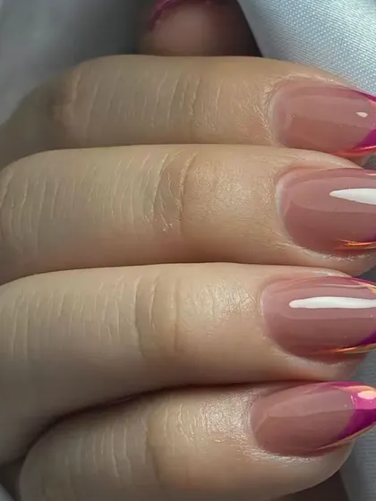 This colorful French manicure uses a vibrant gradient of orange and pink on the tips of almond-shaped nails, creating a beautiful sunset effect.