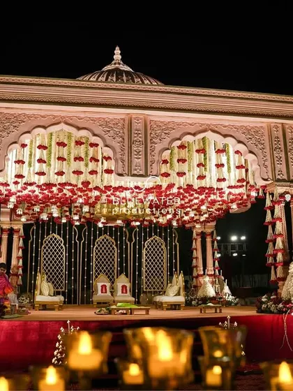 We honor tradition with grandeur. This magnificent wedding stage was inspired by temple architecture, featuring intricate domes, a canopy of red roses, and rich fabrics to create a sacred and royal ambiance.