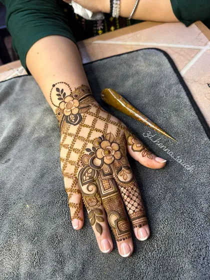 A beautiful floral and net pattern design, perfect for any festive occasion. The henna cone is shown, highlighting the fresh paste we use.
