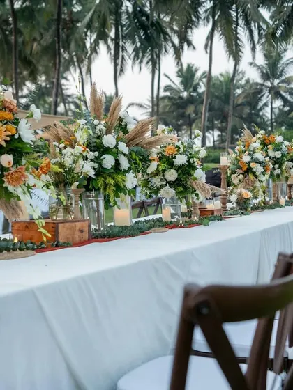 A long table setup for a rustic-boho dinner in Goa, with a runner of pampas grass and wildflowers.