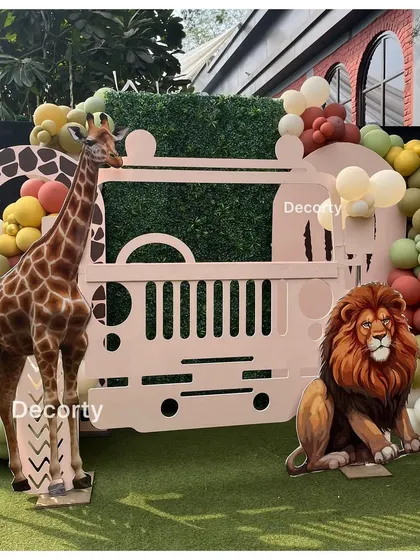 A fantastic jungle-themed photo booth in the shape of a safari jeep, with life-sized giraffe and lion props.