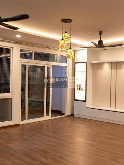 This shot captures the large windows and glass doors that flood the living room with natural light, a key element of our human-centric design approach. The space feels connected to the outdoors.