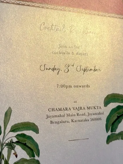 This invitation is printed on a beautiful metallic board that gives the design a subtle shimmer. The tropical leaf illustrations and elegant script font make it perfect for a destination or garden wedding.