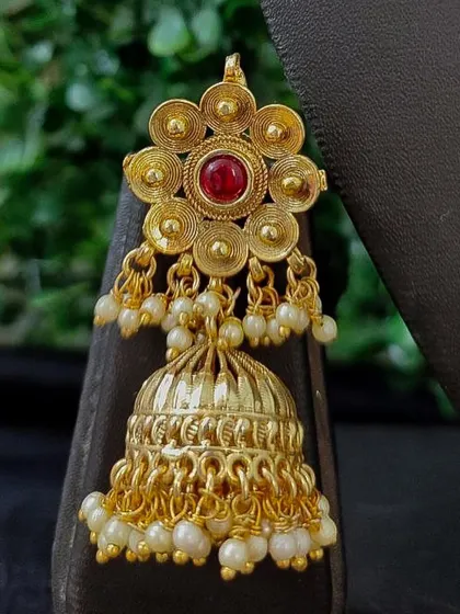A classic gold-tone temple jhumka with a floral top and pearl drops. This rental piece is a timeless accessory for any ethnic outfit.