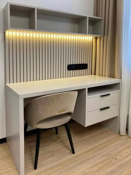 A compact and stylish study table setup, perfect for a bedroom corner. The design includes overhead shelves, drawers, and a fluted panel backsplash with integrated lighting.