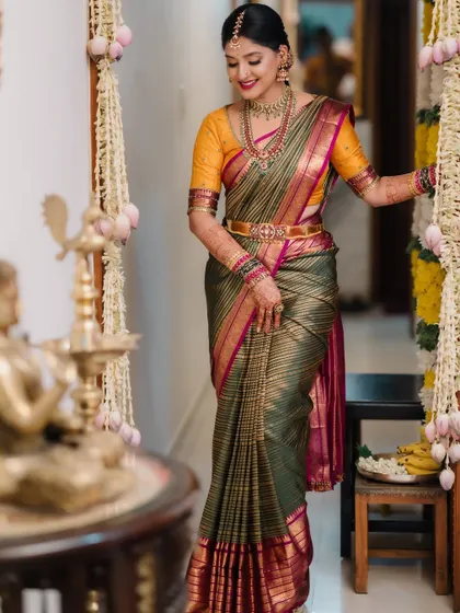 A full-length shot of the bride, her colourful saree standing out against the traditional decor.