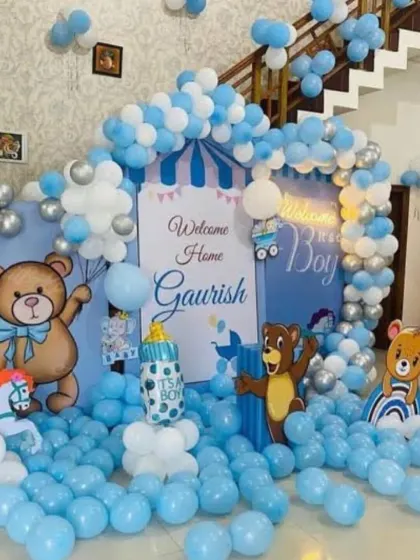 A cute teddy bear theme for a "Welcome Home" or birthday party, with a backdrop featuring a blue and white striped tent and lots of balloons.