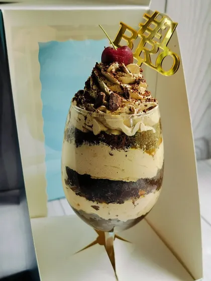 A close-up view of the Mocha Mirage Delight, focusing on the piped coffee mousse, chocolate chunks, and cherry on top.