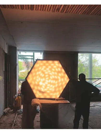 Testing a custom hexagonal light fixture on the construction site. We ensure every detail is perfect before final installation, guaranteeing the quality and intended effect of our designs.