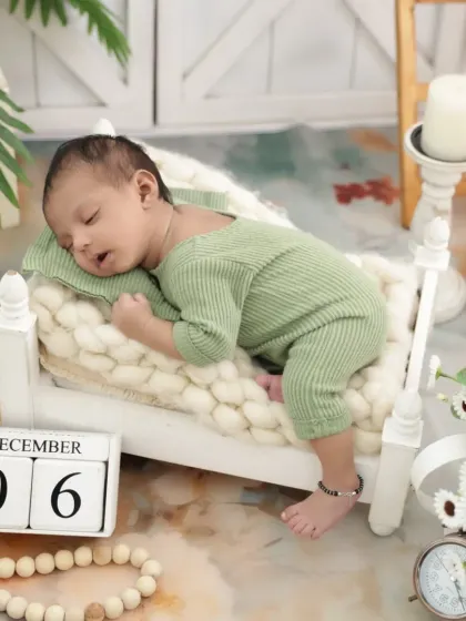Another precious moment from our newborn session, with a calendar marking the special day. The baby is sleeping soundly on a miniature bed prop.