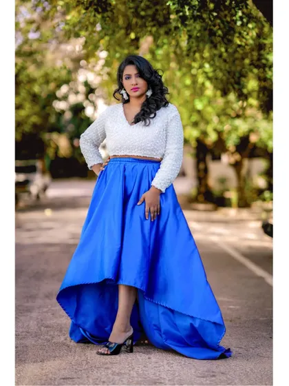 A full-length shot showcasing the modern silhouette of the high-low skirt and crop top combination, a great alternative to a traditional gown for a pre-wedding shoot.