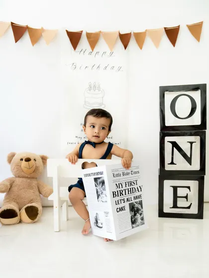 "Extra, extra, read all about it! I'm turning one!" This newspaper prop adds a fun, personalized touch to first birthday photoshoots.