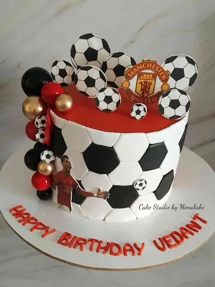 A football themed cake for a Ronaldo fan. This tall cake is decorated to look like a giant football and is topped with more footballs.