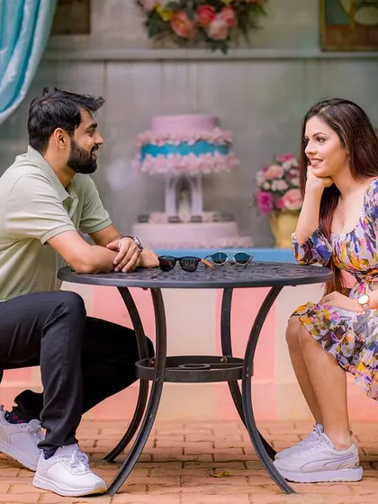 A sweet, candid moment at a cafe-style table. The couple's relaxed poses and the charming setting create a very natural and authentic pre-wedding photo.