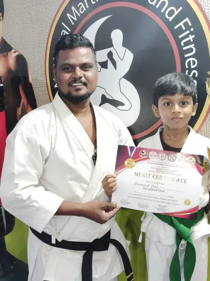 This green belt student proudly displays his first-place certificate and trophy, a reward for his dedication to karate.