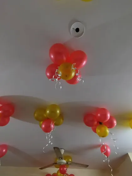 Red and yellow balloon flower clusters attached to the ceiling. This is an easy way to add color and a festive feel to a room, especially in spaces with high ceilings.