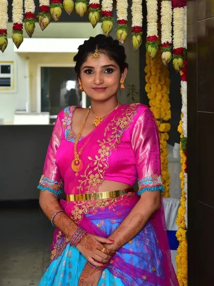 A beautiful color combination for this client's half-saree. The embroidered pink blouse is paired with a blue and purple skirt, creating a vibrant and youthful look.