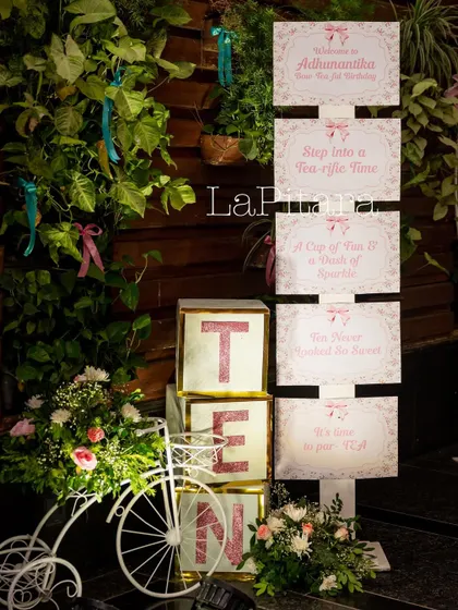 A themed signpost and prop display for the 10th birthday, featuring a decorative bicycle and marquee letters.