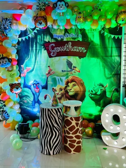 A brightly lit view of the jungle theme setup, showing the details of the balloon garland with animal foil balloons.