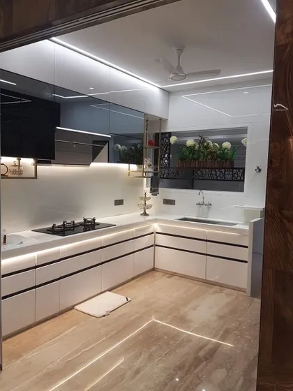 This all-white kitchen is the definition of sleek and modern. The handleless cabinets, integrated lighting in the profiles, and reflective surfaces create a bright, spacious, and high-end feel.