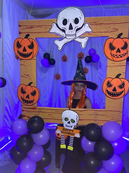 The Halloween photo booth is perfect for kids to show off their costumes. Here, a guest with a witch hat and orange hair gets her picture taken.