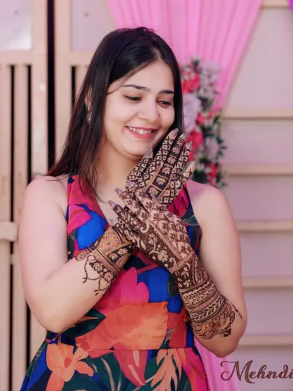 A beautiful shot of a guest admiring her detailed mehendi design.