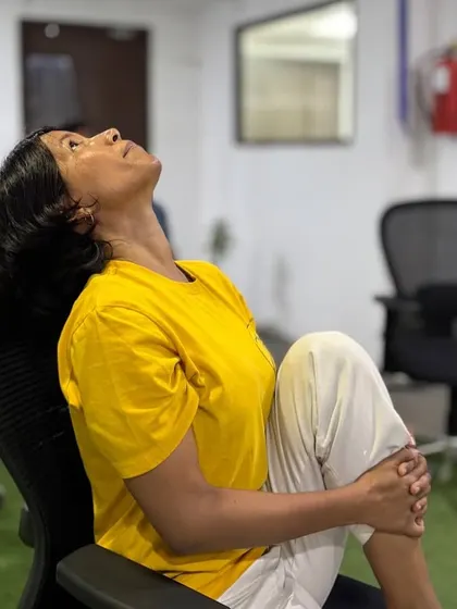 Chair yoga makes the practice accessible to everyone, regardless of flexibility or experience. This seated knee-to-chest pose helps release tension in the lower back and hips, providing immediate relief from the discomfort of prolonged sitting.