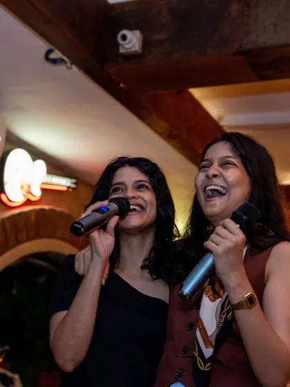 Two friends sharing a mic and a laugh. It's all about having fun, not just hitting the right notes.