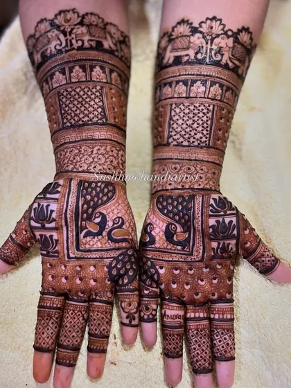 The complete view of a stunning bridal mehndi, with matching designs on both hands extending up the arm.