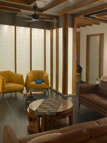 Another view of the Lucknow penthouse living area, where the glowing 'lantern' partitions create a warm and inviting atmosphere. The custom furniture, including the leather sofas and wooden coffee table, is arranged to complement the architectural features.