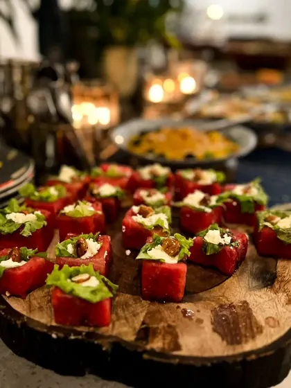 Another look at our popular watermelon and feta bites, presented on a rustic wooden board. This appetizer is a consistent favorite for its refreshing taste and vibrant look.
