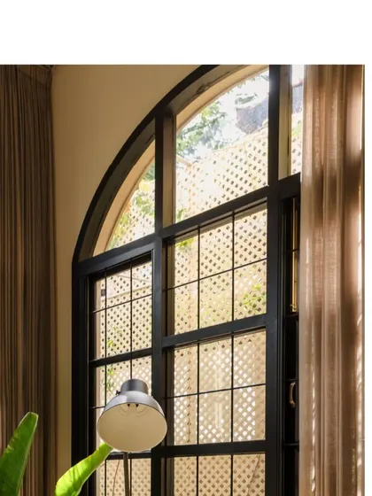 The grand arched windows are a defining feature of Casa 503, connecting the interiors with the lush greenery outside and creating a feeling of openness.