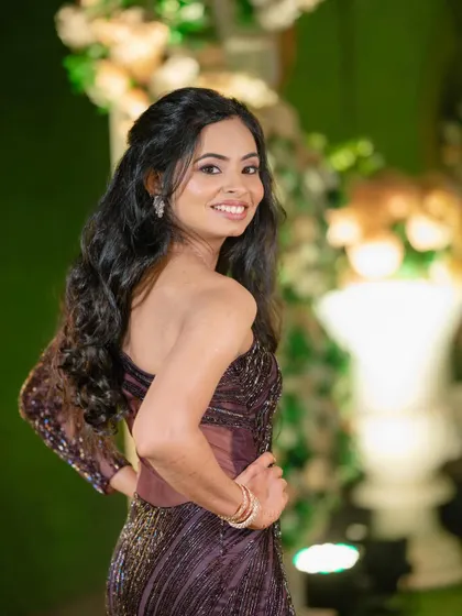 A confident and happy bride. Her smile and the over-the-shoulder pose show off her beautiful hairstyle and the elegant simplicity of her makeup.