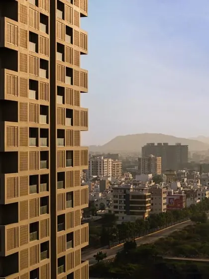 'SCREEN 504' set against the Udaipur city skyline. The building's design thoughtfully integrates with its urban and natural surroundings, respecting both context and climate.