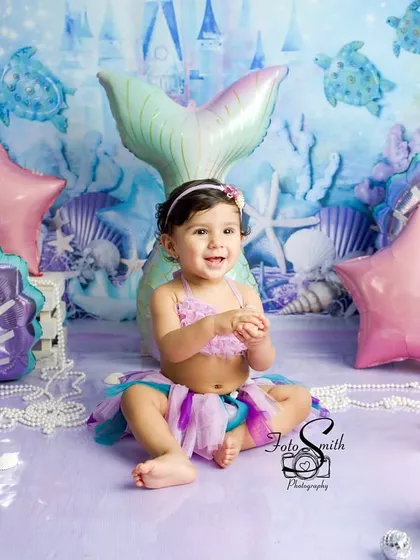 Clapping with joy in her underwater kingdom. I focus on capturing these spontaneous expressions of happiness that truly define the spirit of a first birthday.