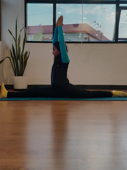 This is Charvi, the inspiration behind our kids' yoga program. Her dedication is incredible, and here she demonstrates a perfect center split, showcasing the flexibility and discipline that yoga helps cultivate.