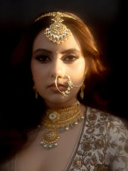 A stunning close-up of the bride, Urjaa. The soft, dreamy focus and the beautiful lighting highlight her intricate jewelry and confident gaze.