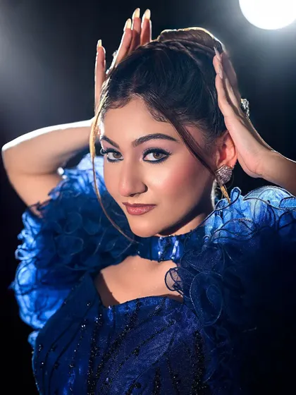 A close-up of the blue gown look, highlighting the sharp winged liner and confident pose.