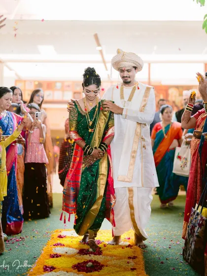The couple walking down a path of flowers, showered with blessings from their guests.