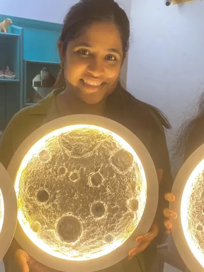 A participant's smile says it all as she holds her glowing, self made moon lamp.