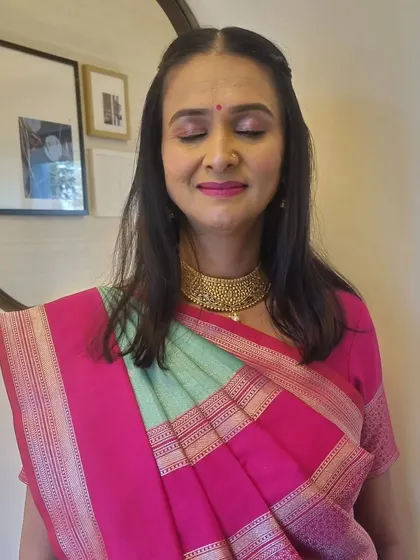 A close-up of the soft pink eye makeup and matching lip color, which looks beautiful with her traditional saree.