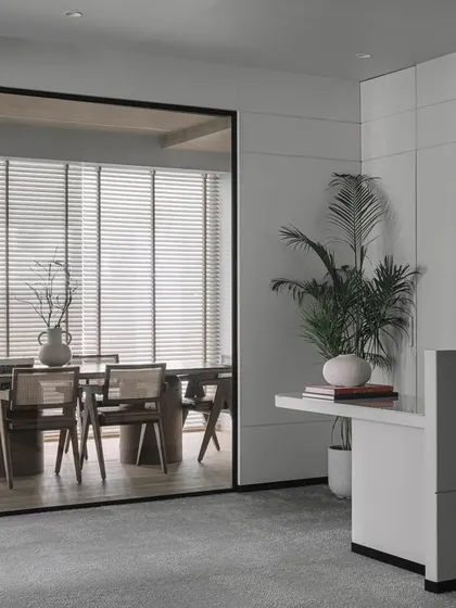 The entrance to this office was designed to be professional yet welcoming. A smoked glass partition offers a glimpse into the meeting room, balancing privacy and openness, while a clean, minimalist reception desk sets a sophisticated tone.