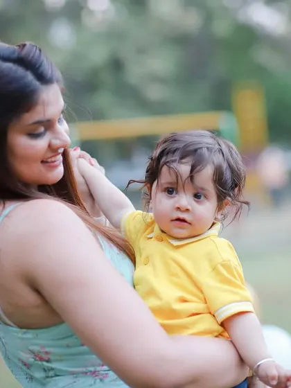 A mother holds her son during his pre-birthday outdoor shoot. A sweet and natural portrait.