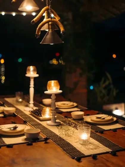 A candlelit dinner scene featuring our monochrome table runner. The elegant design and tassel details add a touch of sophistication to this intimate and rustic table setting.