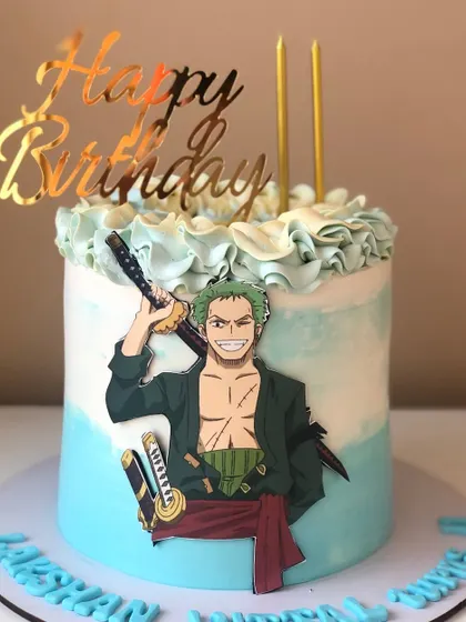 A cool cake for a One Piece fan, featuring the swordsman Roronoa Zoro. The blue and white wave-like icing completes the theme.